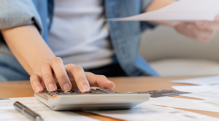 Woman calculating amount she needs to repay monthly for her personal loan in Singapore